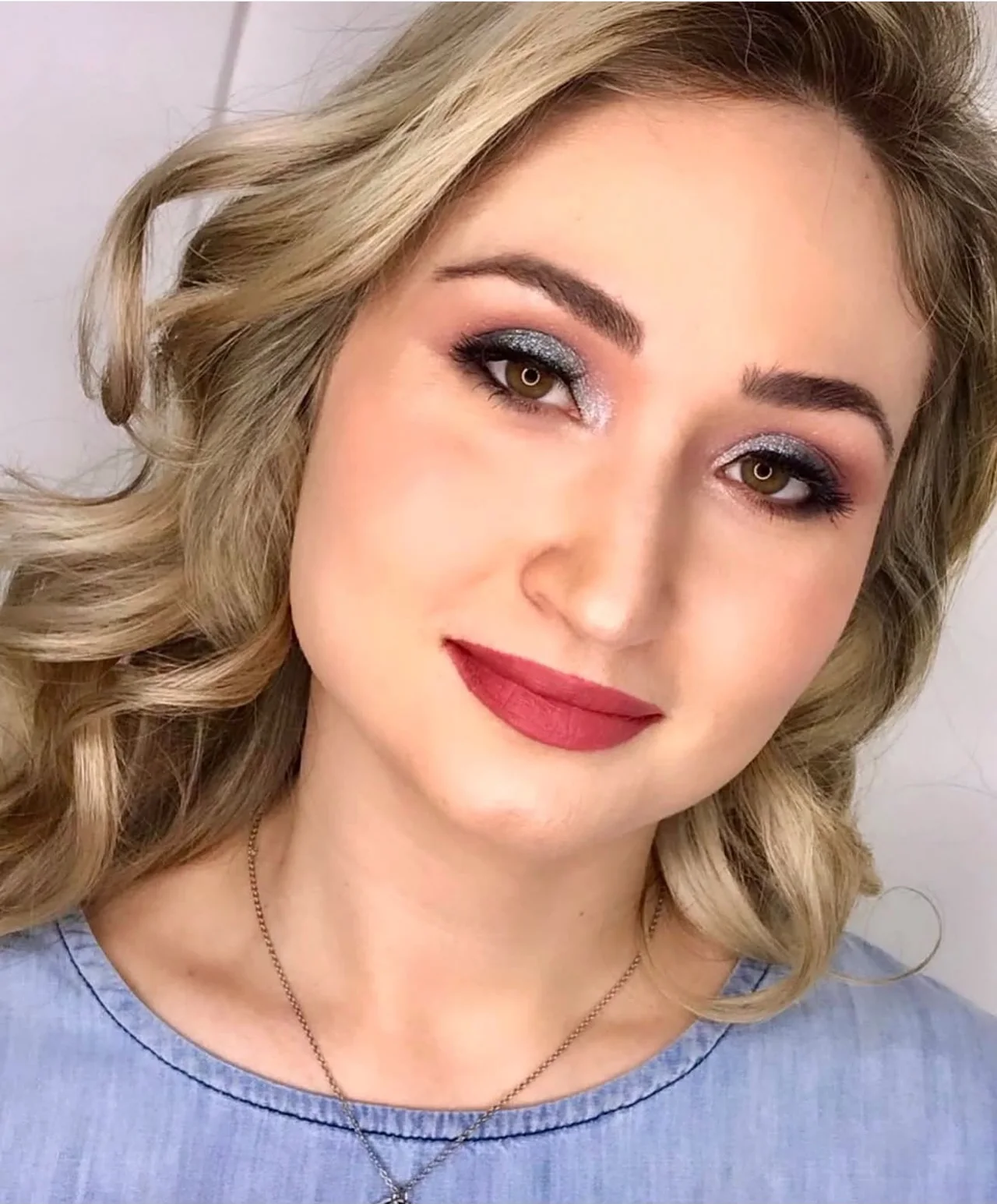 Maquiagem com olhos marcados e batom vermelho, trabalho do Romana Hair Studio