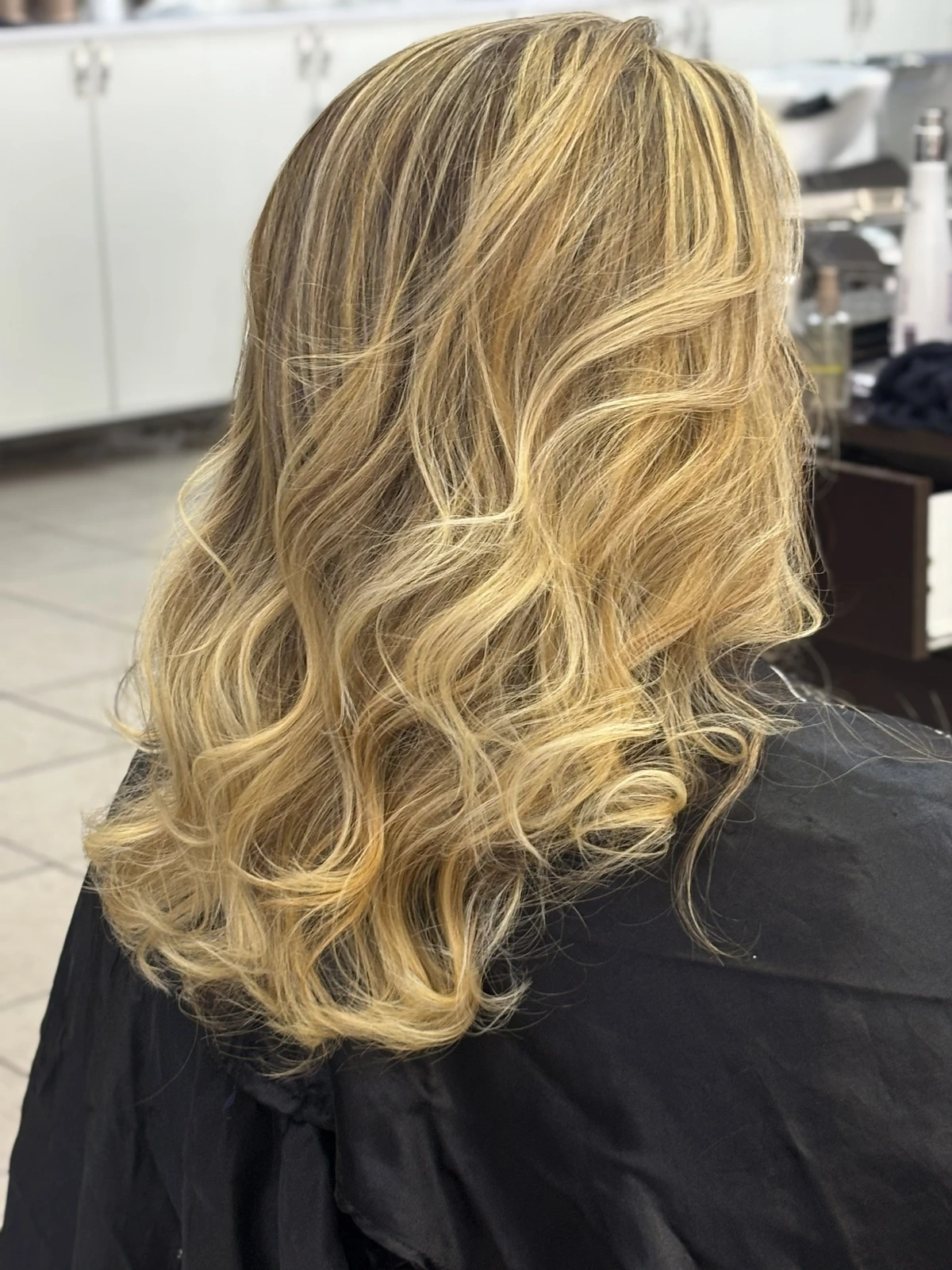 Cabelo loiro em camadas com acabamento ondulado, trabalho de Selma no Romana Hair Studio