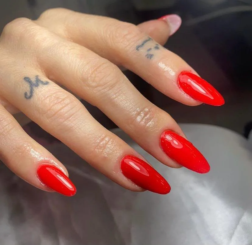 Unhas vermelhas longas com acabamento brilhante, resultado real da equipe Romana Hair Studio