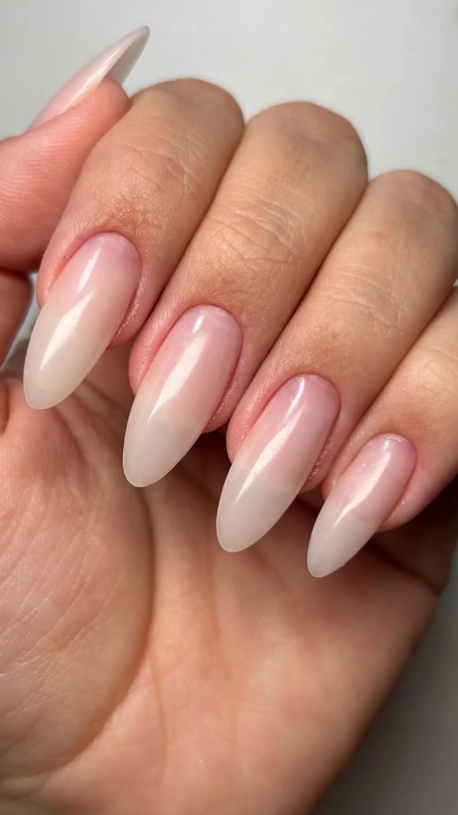 Unhas em tom nude com formato amendoado