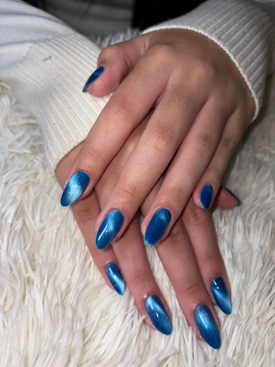 Unhas em azul intenso com acabamento brilhante, resultado real da equipe Romana Hair Studio